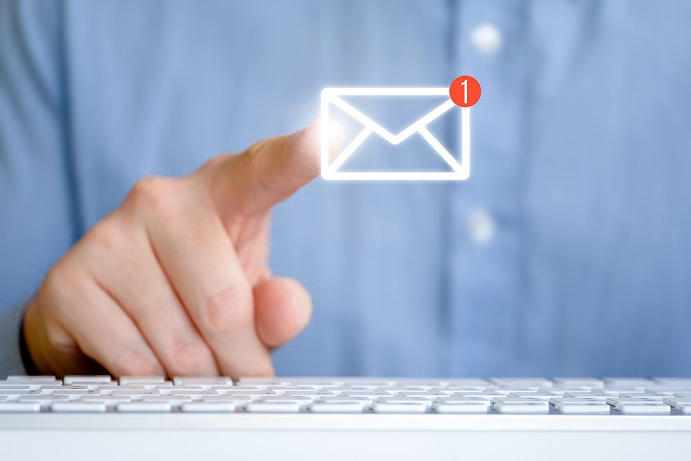 A man in a shirt in front of the keyboard. Abstract email icon with new message. Internet feedback concept.