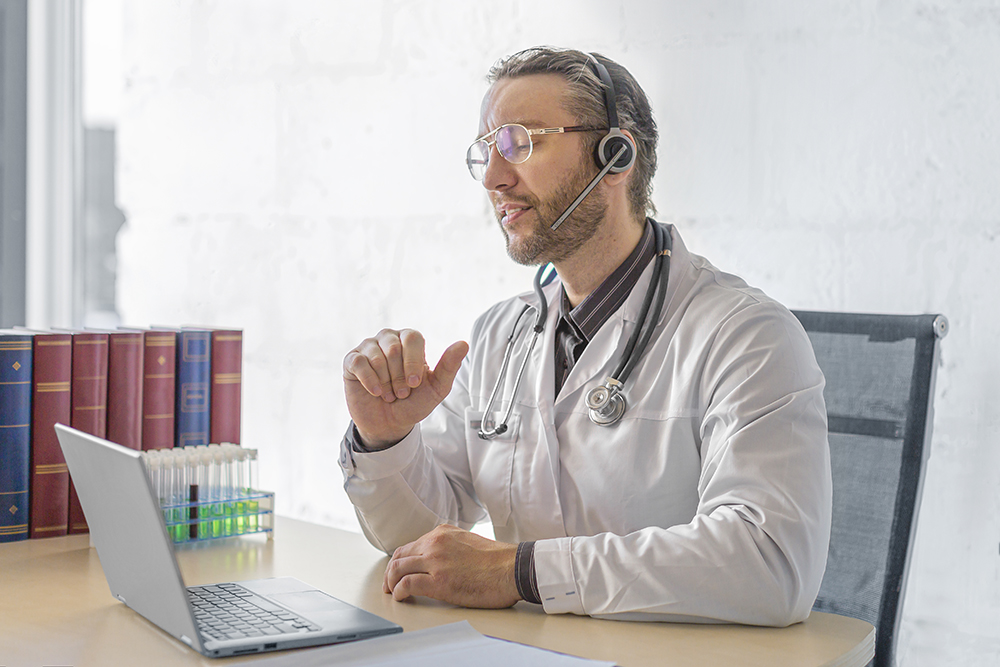 Photo of a middle aged doctor during an online consultation with a patient.